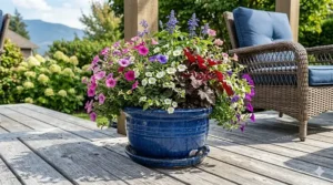 A large round ceramic planter filled with summer flowers on a patio.