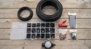 Flat lay of all components included in a standard drip irrigation kit under $100 CAD, including blank supply tubing, barb fittings, and punch tools.