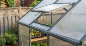 Close-up of twin-wall polycarbonate panels and a roof vent on a 6x8 greenhouse kit for optimal temperature control.